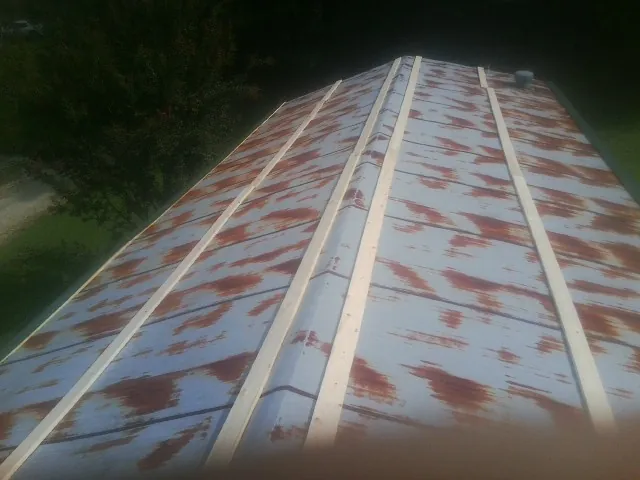 Rusted metal roof panels with new wood purlins before replacement — Storm Damage Roof Repair in Meadow by Roofing Brothers