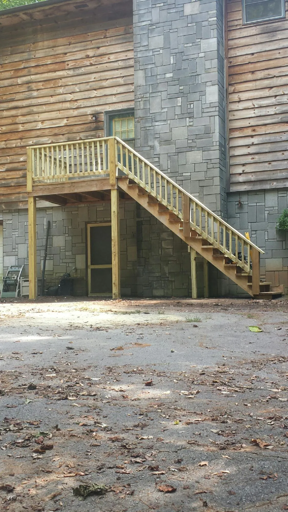 New pressure treated deck and stair landing on a log home in Meadow
