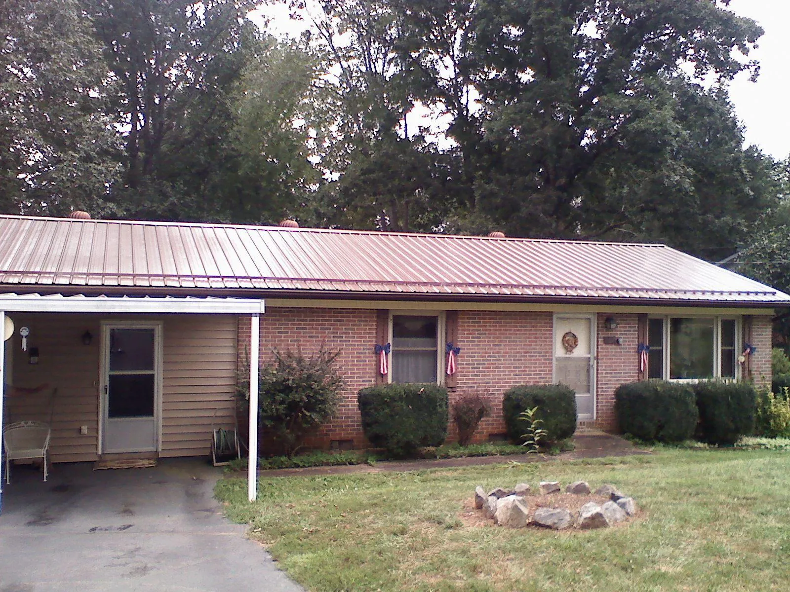 Bronze metal roof and carport on a brick ranch home — Roof Repair work by our crew in Meadow
